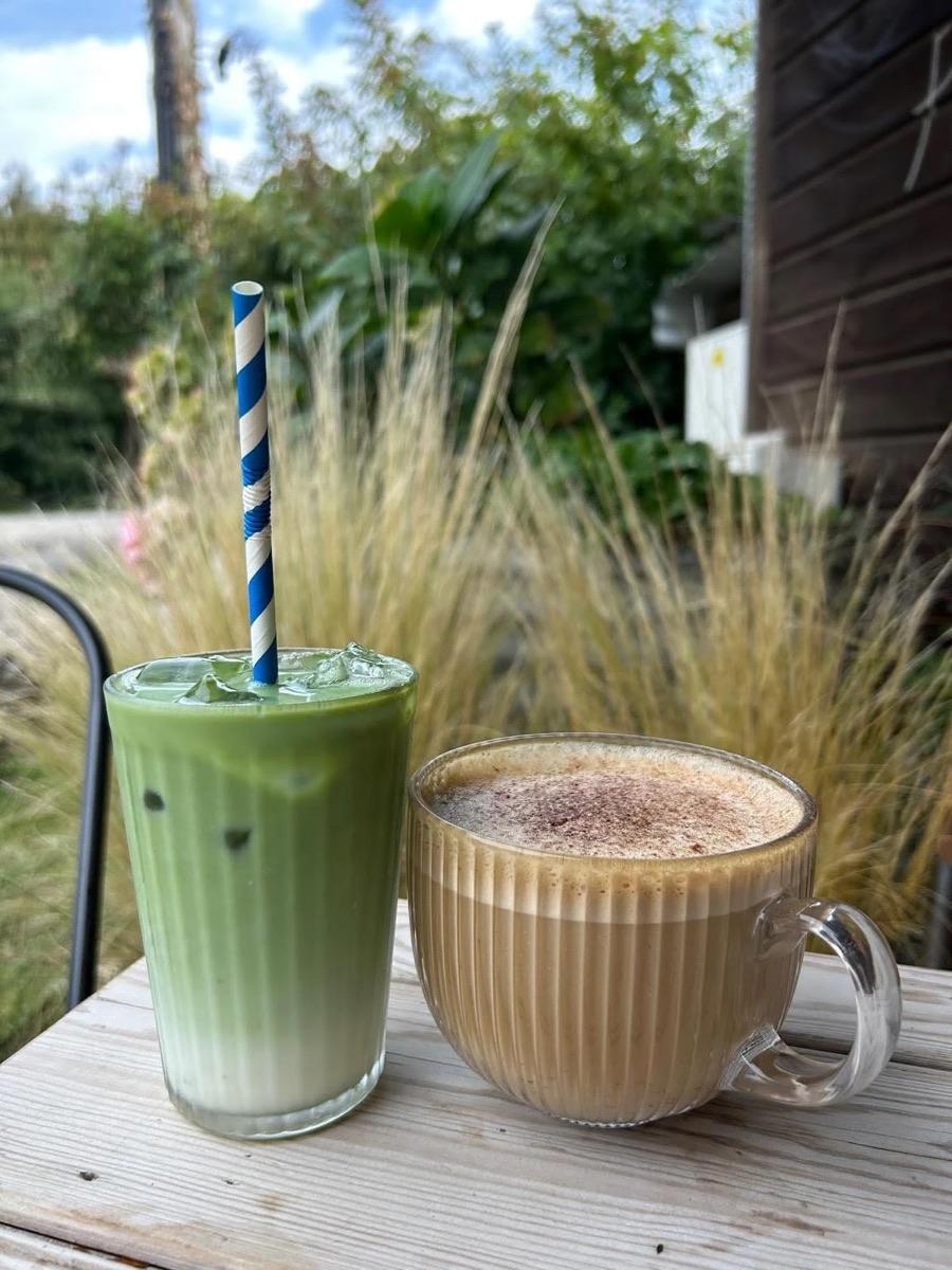 An iced matcha latte and a coffee on a table in the caf&eacute; garden
