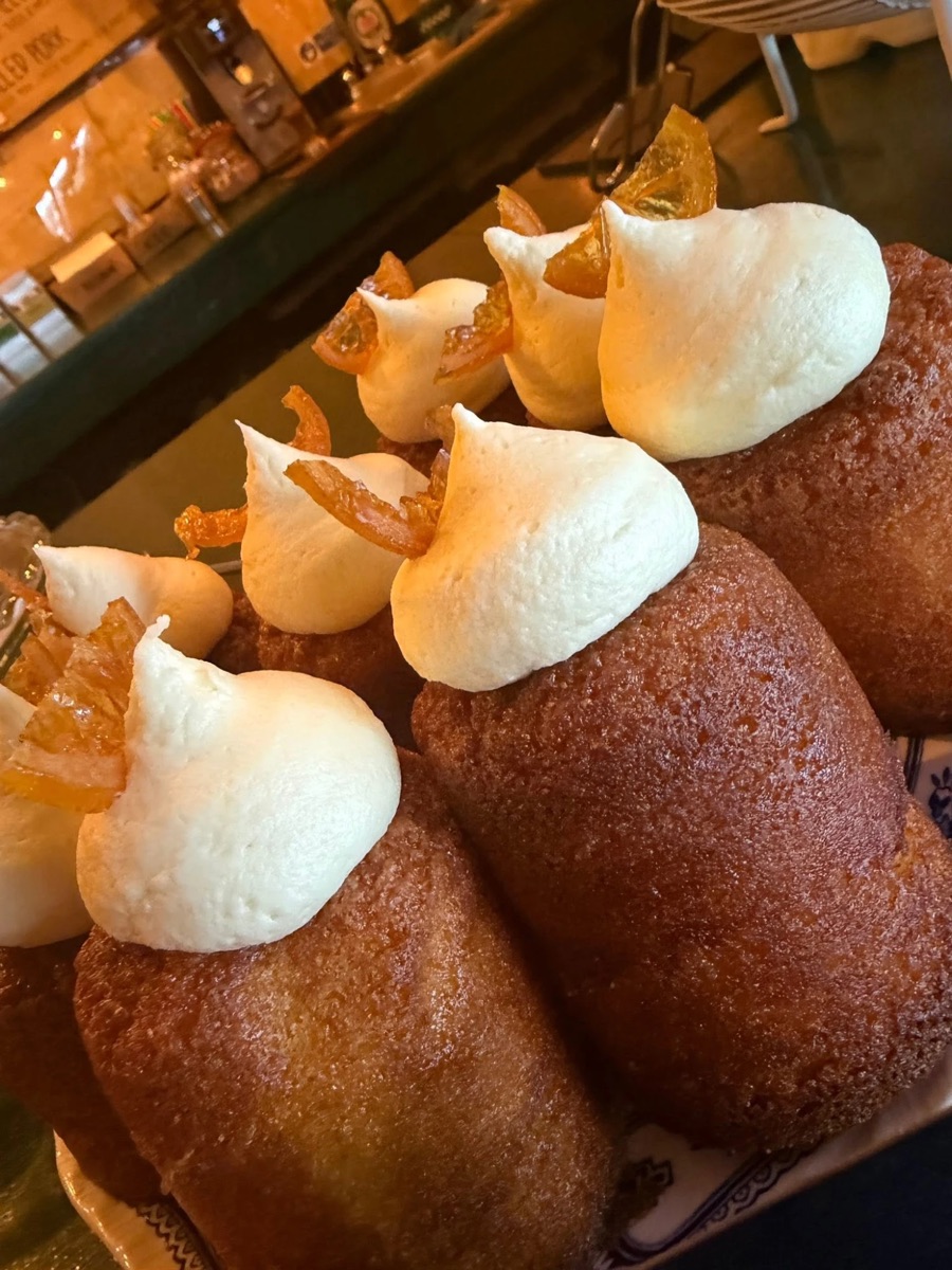 Syrup-soaked cakes topped with cream and candied orange